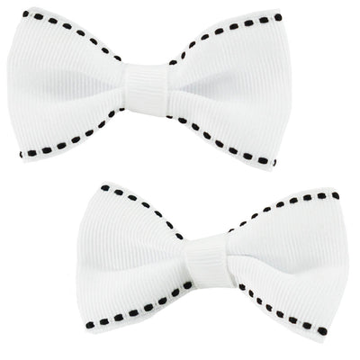Two white bow hair clips with black trim