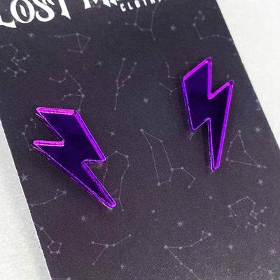Retro alternative purple lightning bolt stud earrings on a black cardboard packaging