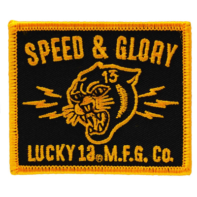 a tattoo style image of a lion and the words "Speed & Glory" on an embroidered iron on patch