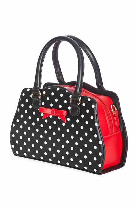 side view of black handbag with white polka dots and red inside