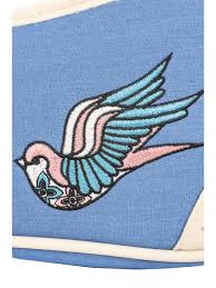 Tattoo-style bird design on a blue background