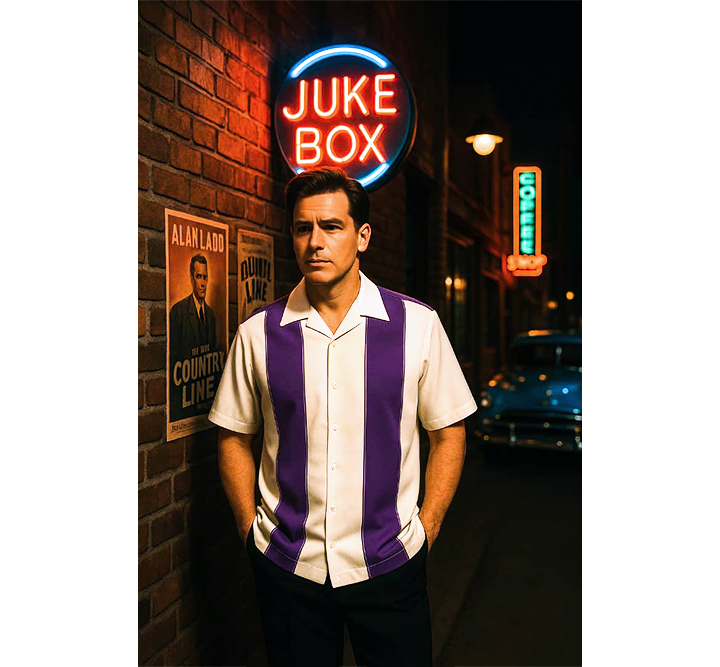 Man in a striped shirt standing in front of a neon 'Juke Box' sign at night.