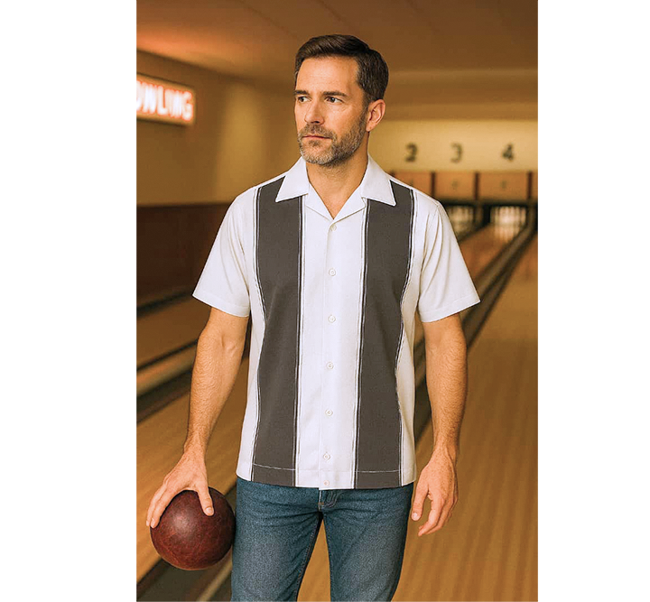 Man in a striped bowling shirt holding a ball in a bowling alley