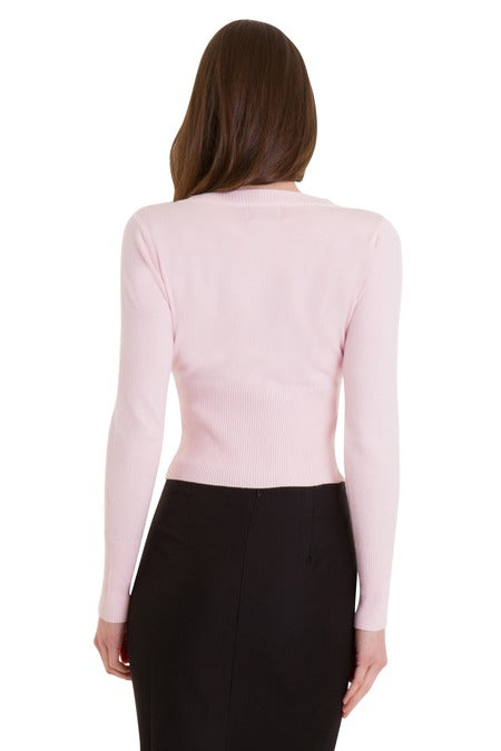 back image of lady wearing a light pink cardigan and black skirt