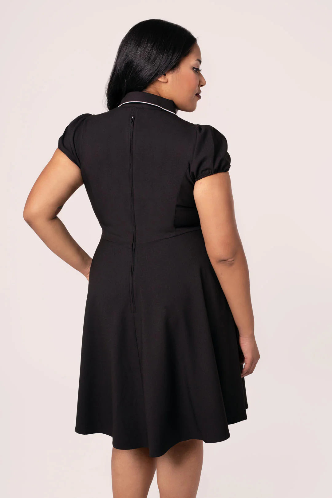 Woman wearing a black dress against a white background