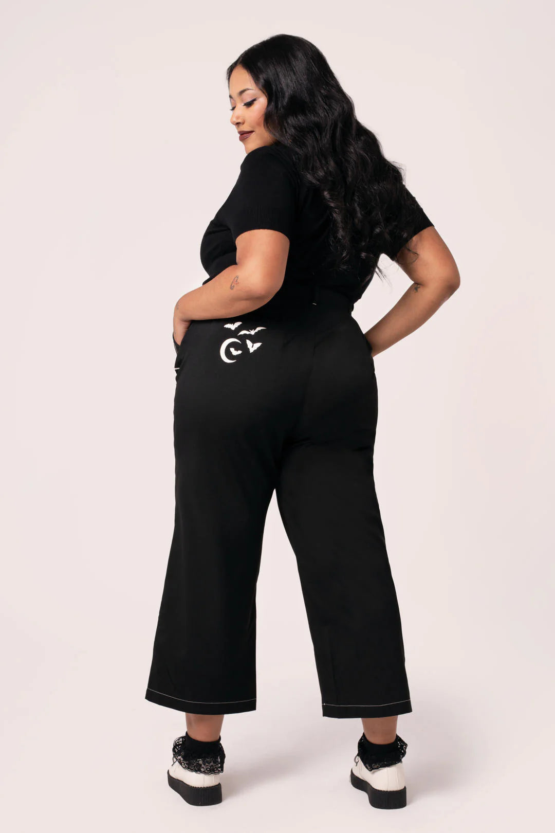 Woman wearing a black outfit with a logo on a white background