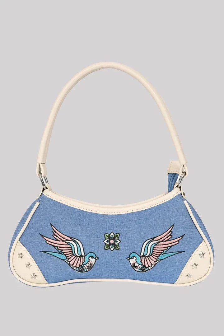 Blue handbag with bird designs on a gray background