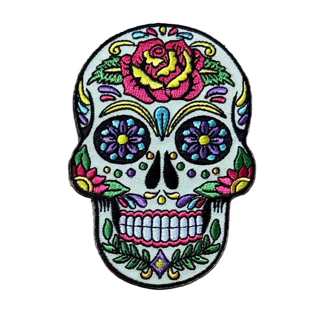 Colorful skull patch with floral designs on a wooden surface