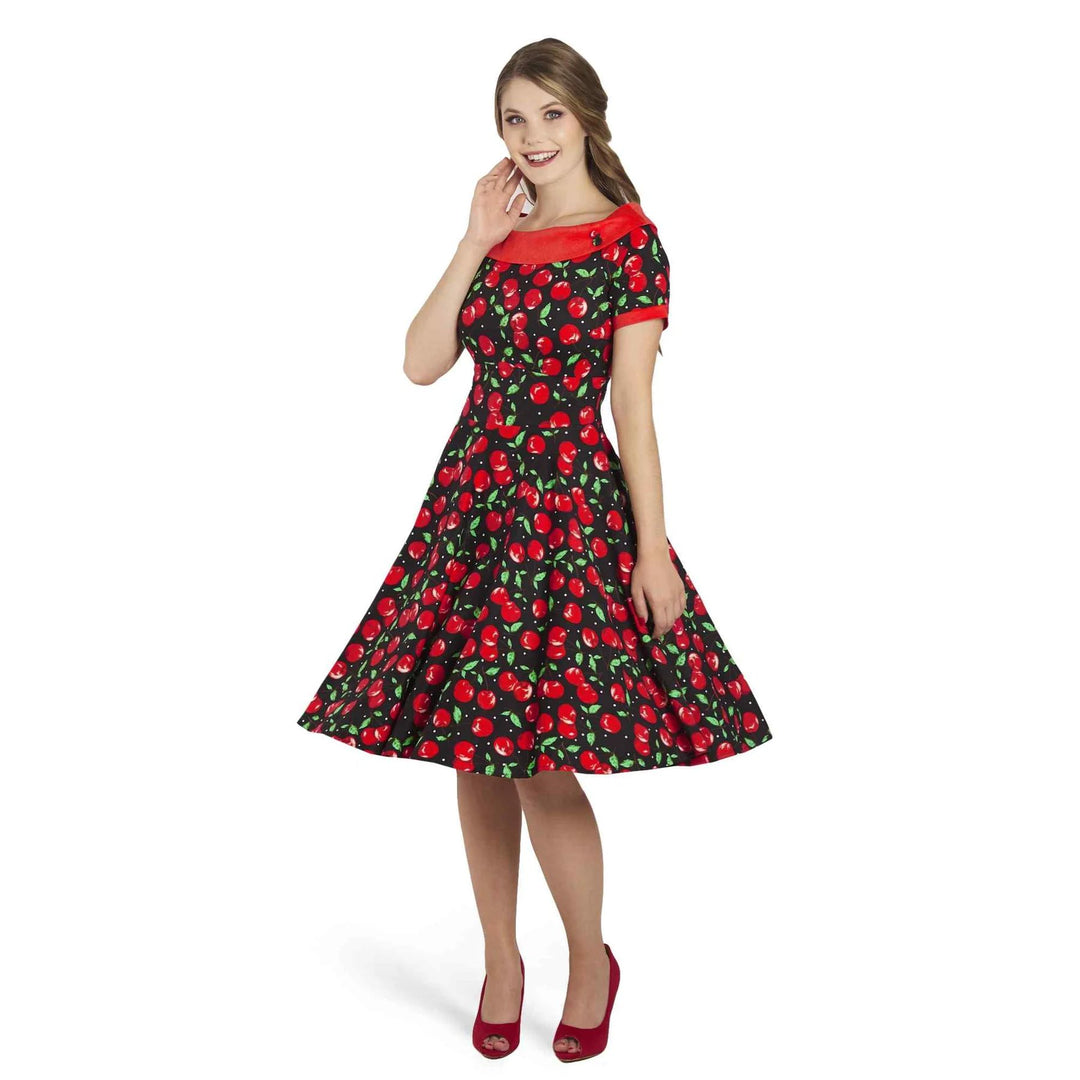 Front image of young lady wearing a boat neck black dress with cherry pattern 