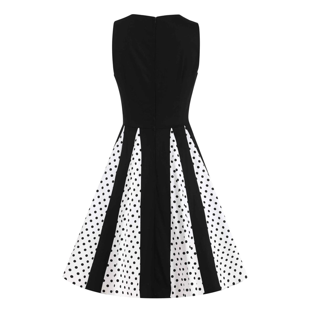 Back image of a black and white pleated dress with black polka dots from the waist down 