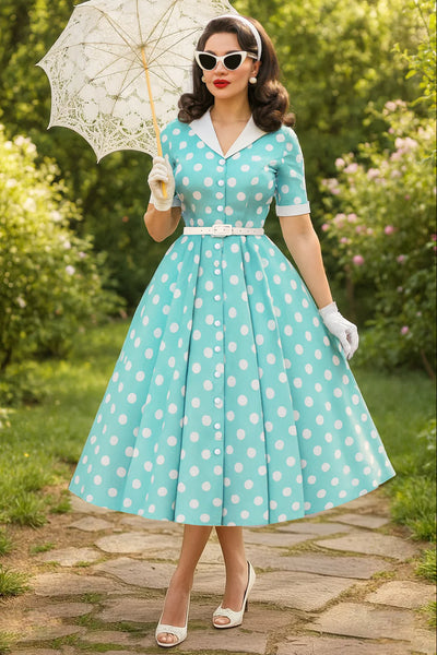 Woman in a vintage-style polka dot dress holding an umbrella in a garden setting