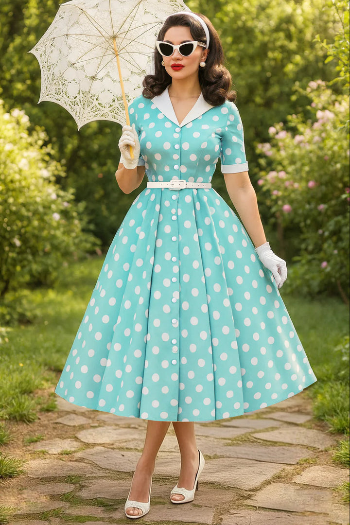 Woman in a vintage-style polka dot dress holding an umbrella in a garden setting