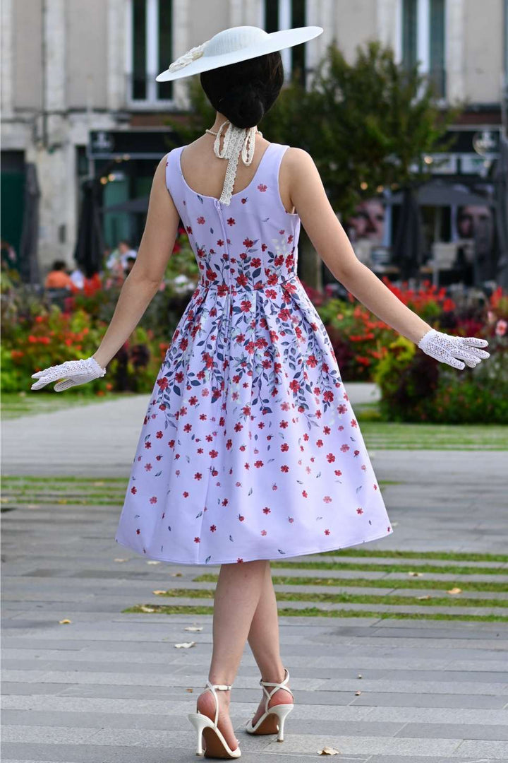 Back of a Woman in a floral dress and hat walking outdoors 