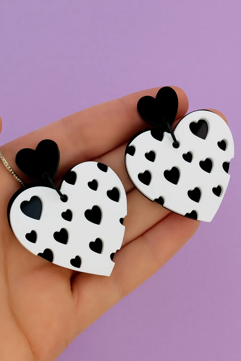 White heart-shaped earrings with small black heart patterns.