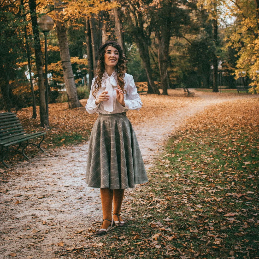 Woman standing in a park with autumn leaves and trees