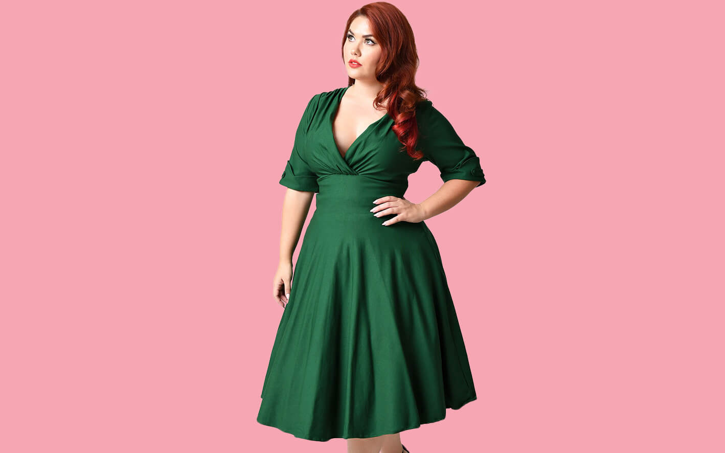 Plus size model wearing the Delores emerald green retro dress