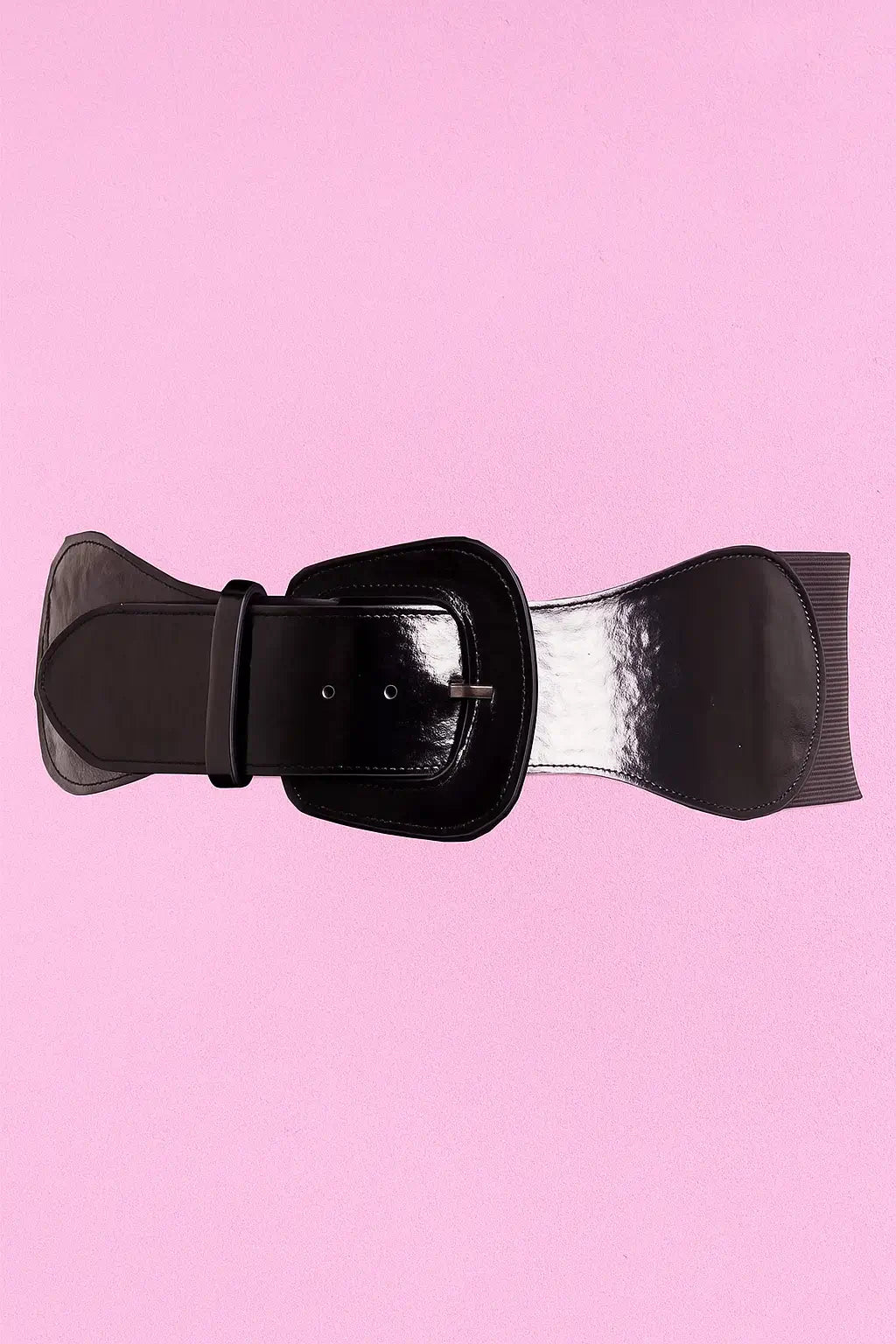 Two black patent leather belts with matching buckles on a pink background.