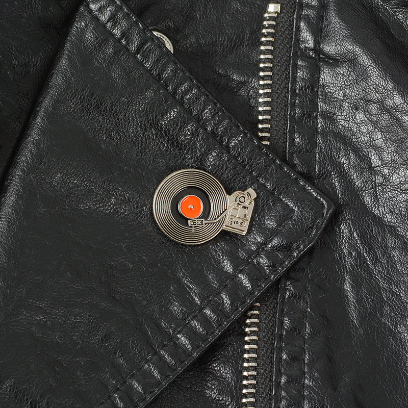 a black leather jacket with an retro enamel pin on the lapel