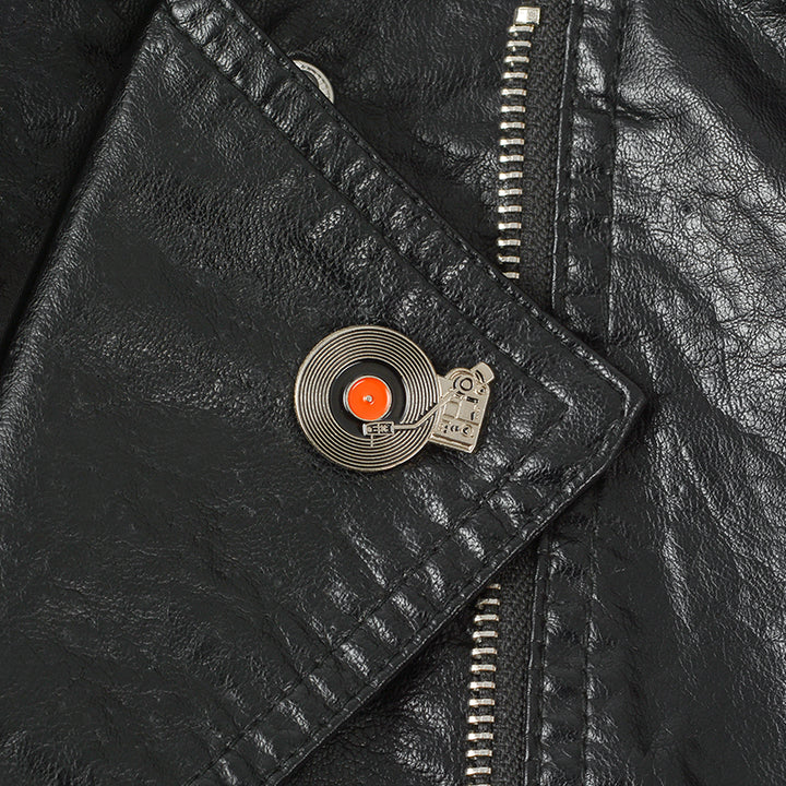 a black leather jacket with an retro enamel pin on the lapel