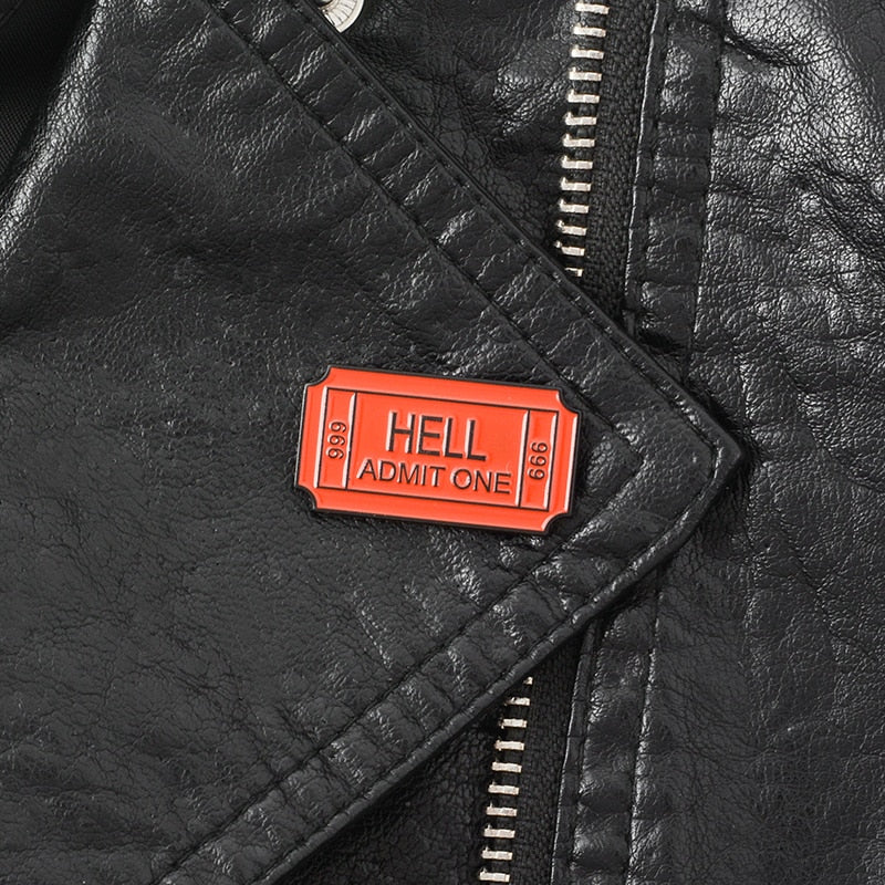 Black leather jacket lapel with a Red enamel pin saying "Hell Admit One 666"