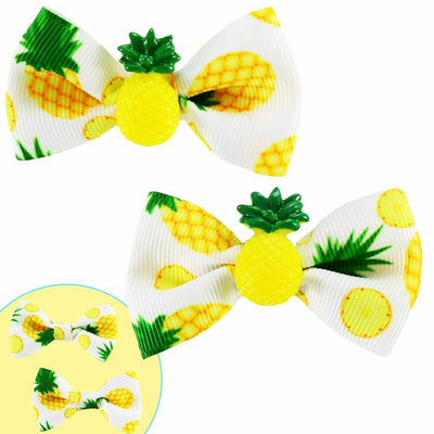 A set of 2 pinapple hair bows, one with a resin pinapple in the middle the other set without