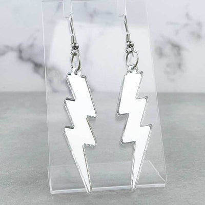 Alternative retro 80s style Lightning bolt hook earrings.  The earrings a mirror sliver laser cut acrylic and are on a clear plastic shop display