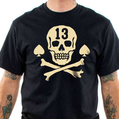 Front view of tattooed model wearing the Lucky 13 Pirate Skull t-shirt. Cream Skull and crossbones with aces at the side and a "13' cuto of of the forehead of the skull
