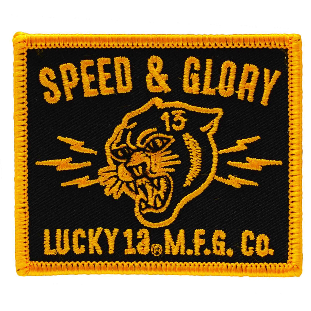 a tattoo style image of a lion and the words "Speed & Glory" on an embroidered iron on patch